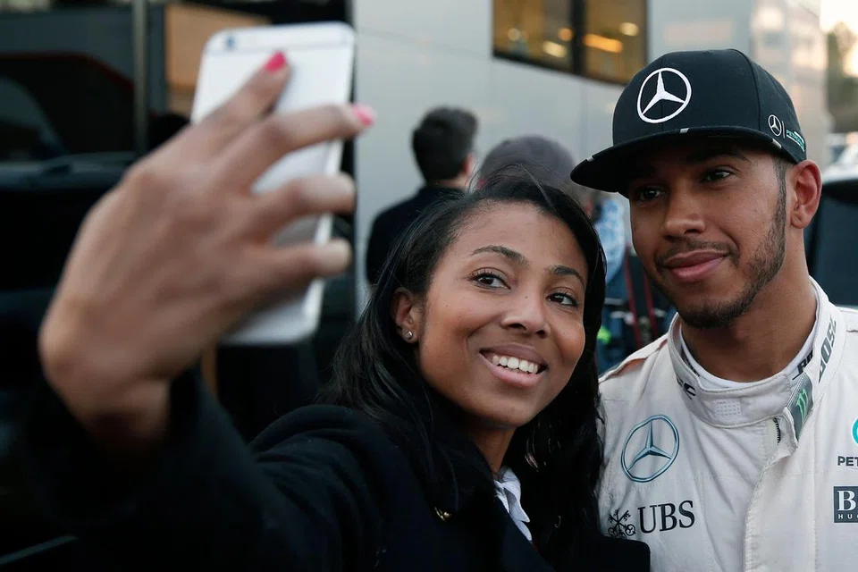 SEMPAT BERSELFIE: Lewis Hamilton berselfie dengan seorang peminat dalam satu sesi ujian di Barcelona, Sepanyol, bulan lalu.