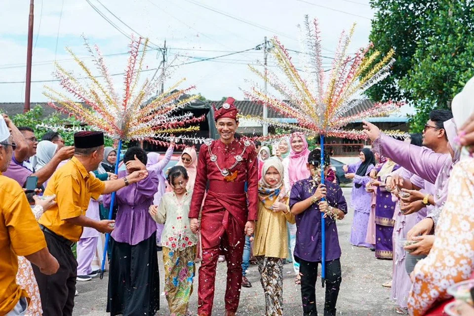 ‘MERIAH’: Pengantin lelaki Encik Ahmad Al-Amin Ahmad Rais, 25 tahun, berarak masuk ke tempat acara tanpa pasangannya.