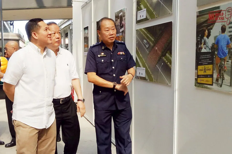 JALAN RAYA LEBIH SELAMAT: Encik Amrin (kiri) dibawa berkunjung ke pameran yang diadakan sempena pelancaran 'Kempen Jalan Raya Lebih Selamat' tahun ini di Hab Tampines Kita. Bersama beliau ialah (dari kanan) Pegawai Pemerintah Cabang Keselamatan Jalan Raya Polis Trafik, DSP Soh Wan Khuan, dan Pengerusi Majlis Keselamatan Jalan Raya Singapura, Encik Bernard Tay. - Foto ERVINA MOHD JAMIL