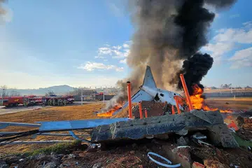 Anggota bomba memadamkan api pada pesawat Jeju Air yang tergelincir dari landasan di Lapangan Terbang Antarabangsa Muan di Wilayah Jeolla Selatan, Korea Selatan, pada 29 Disember. 