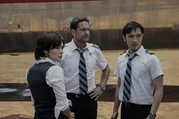 TANGANI CEMAS: Gerard Butler (tengah) selaku juruterbang, Brodie Torrance, dalam 'Plane' menampilkan semangat wira untuk mengatasi rasa cemas penumpang pesawatnya menjadi tebusan. Bersamanya adalah Daniella Pineda selaku Bonnie Lane (kiri) dan Yoson On sebagai Samuel Dele. - Foto WARNER BROS