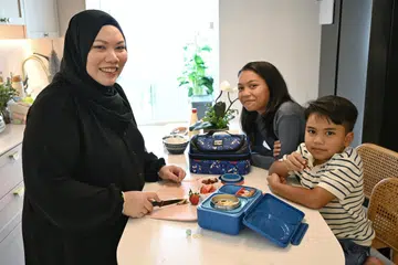 Cik Nordian Razali (kiri) selalu memasak dan menyediakan bekal untuk anak-anaknya, Nadya Raessa, 10 tahun (tengah), dan Raees Nadym, tujuh tahun, nikmati semasa waktu rehat di sekolah.