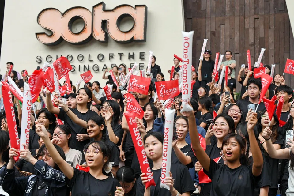 Para pelajar dari Sekolah Seni Singapura (Sota) berhimpun untuk menyambut ketibaan atlet negara semasa perarakan. Mereka adalah antara 13 rakan kongsi Majlis Sukan Singapura yang hadir untuk menyemarakkan lagi acara perarakan yang diadakan di kawasan bandar pada 14 Ogos. 