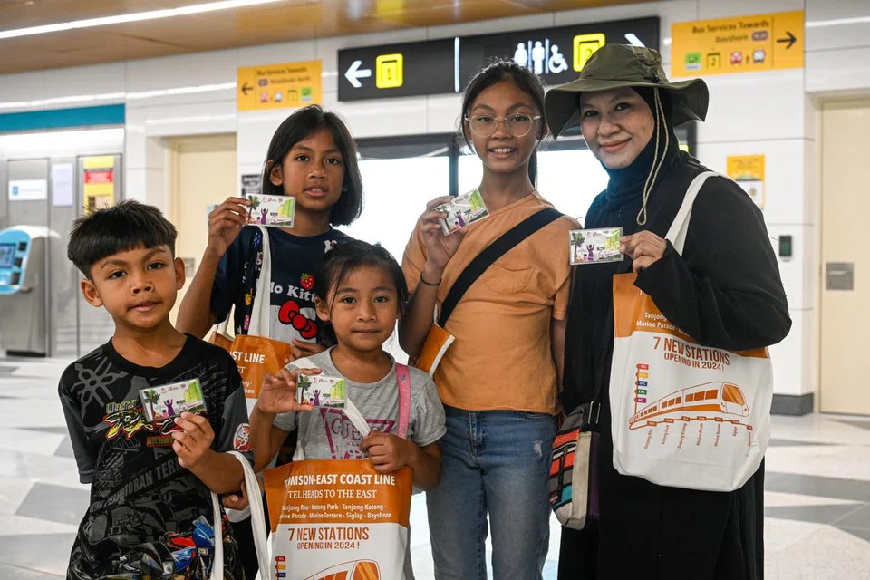 Cik Hadijah Iszal (kanan) dan keluarganya adalah antara penduduk yang menyertai acara Walk N Ride dan menerima kad ez-link edisi terhad hasil kerja Nur Aneesa Inshirah Muhammad Yazzid. 