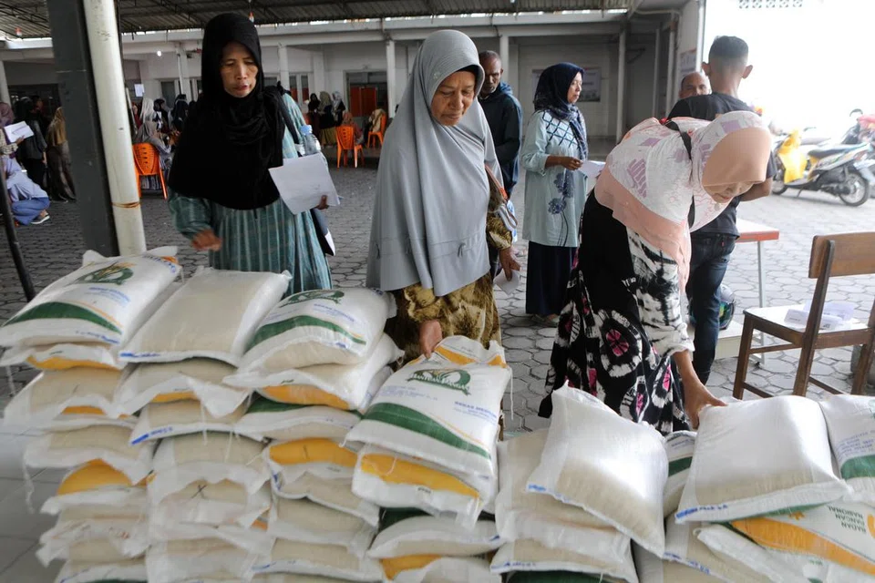 Penduduk menerima bantuan beras semasa kempen agihan bantuan makanan di Banda Aceh, Indonesia, pada 6 Mac. Bagi mengawal kenaikan harga makanan, pemerintah mengambil beberapa langkah iaitu menyediakan bantuan beras kepada 22 juta penduduk.