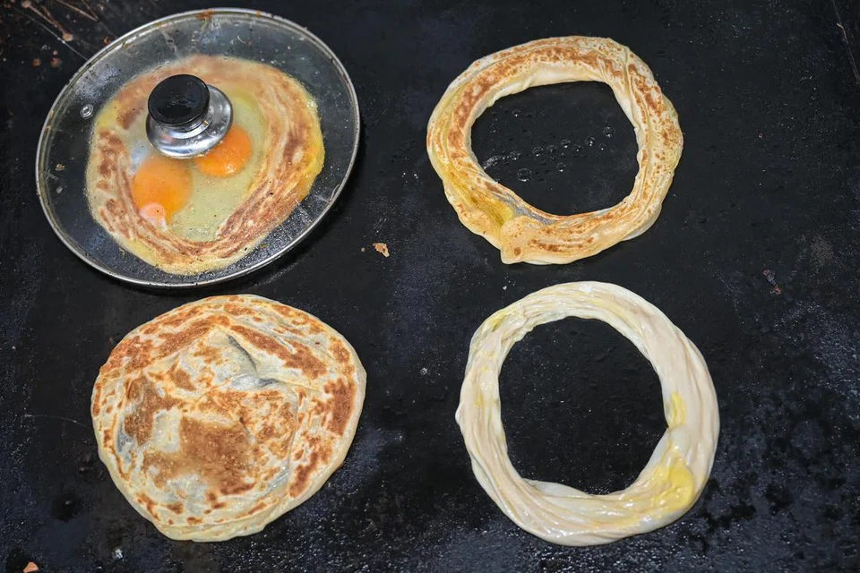 Doh perata dibentuk lopong dan dipecahkan dua telur di tengah semasa proses mamasak. 