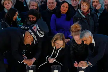 DALAM KENANGAN: Encik Khan (kanan) dan Setiausaha Ehwal Negara Britain, Cik Amber Rudd (tengah), bersama orang ramai di Dataran Trafalgar kelmarin bagi memperingati tragedi Rabu lalu. - Foto AFP