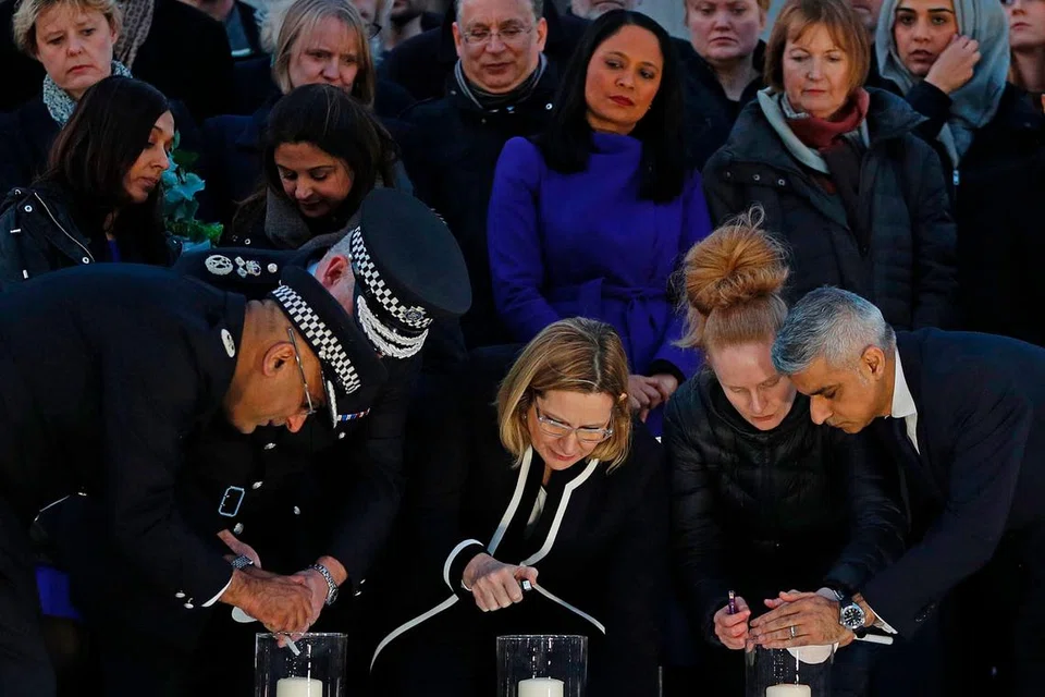 DALAM KENANGAN: Encik Khan (kanan) dan Setiausaha Ehwal Negara Britain, Cik Amber Rudd (tengah), bersama orang ramai di Dataran Trafalgar kelmarin bagi memperingati tragedi Rabu lalu. - Foto AFP