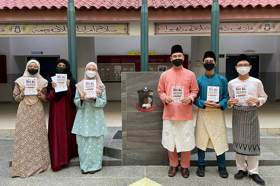 CARA TUNJUK PENGHARGAAN: Pelajar Madrasah Aljunied menggunakan kad yang diberikan kumpulan Bapa Sepanjang Hayat menulis penghargaan mereka sempena Hari Bapa. - Foto MADRASAH ALJUNIED