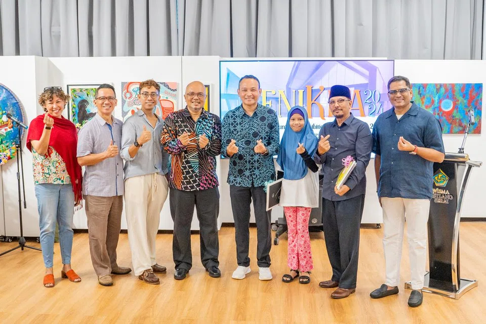 (Dari kiri) Pengurus Kamal Art, Cik Eliyah Osman; Pengurus Besar Wisma Geylang Serai (WGS), Encik Mokhtar Jaffar; Naib Johan Karya Terbaik, Muhd Mitaq; pengasas Kamal Arts Limited, Encik Kamal Dollah; Mayor Majlis Pembangunan Masyarakat (CDC) South East, Encik Mohd Fahmi Aliman; pemenang Anugerah Artis Harapan, Liya Amira; pemenang Karya Terbaik, Saiman Ismail; dan Penolong Pengarah Jabatan Daerah Jalur Budaya Geylang Serai, Encik Hajah Mohaideen Kamal Batcha, di pameran SeniKita di Wisma Geylang Serai (WGS) pada 16 November. 