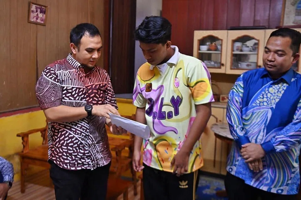 RINGANKAN BEBAN: Setiausaha Politik Perdana Menteri, Encik Ahmad Farhan Fauzi (kiri sekali) menyampaikan sumbangan kepada Encik Abdur Rahman Amir Ruddin yang kehilangan enam ahli keluarga termasuk kedua ibu bapanya yang terkorban dalam nahas jalan raya pada petang Jumaat lalu.