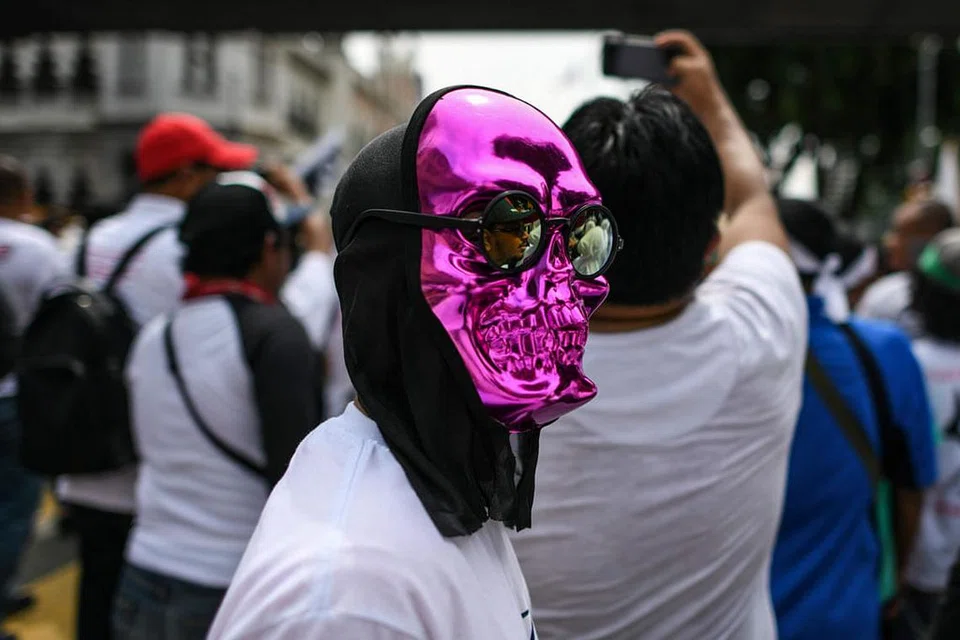 BERTOPENG: Seorang peserta memakai topeng semasa perhimpunan anti-ICERD di Dataran Merdeka di Kuala Lumpur semalam. - Foto AFP