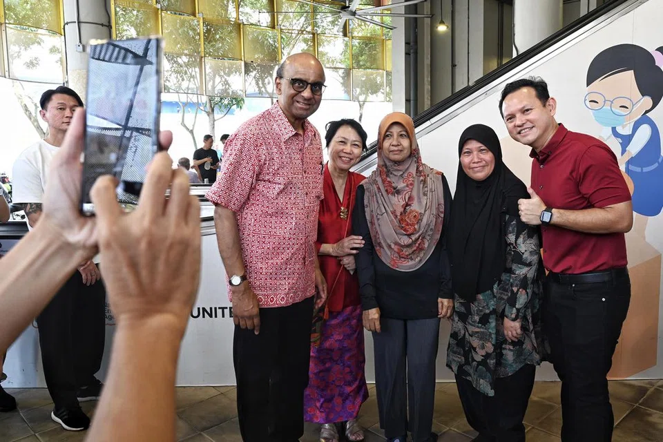 AMAT MESRA: (Dari kiri) Bakal Presiden Singapura, Encik Tharman Shanmugaratnam, serta isteri, Cik Jane Ittogi, bergambar bersama penduduk Marsiling, Cik Kamariah Abdul Majid (tengah) dan Cik Rozana Salleh (dua kanan) ketika lawatan beliau ke Pusat Penjaja Marsiling Mall. Turut hadir untuk menyambut ketibaan beliau ialah Encik Zaqy Mohamad (kanan). 