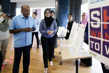 PERLU TINGKATKAN KESEDARAN: Menteri Ehwal Dalam Negeri merangkap Undang-undang, Encik K Shanmugam (kiri) melihat pameran semasa Minggu Kesedaran Keganasan Dating (DVAW) di Treetop@SCAPE semalam. Bersama beliau ialah pekerja sosial kanan Pave, Cik Adisti Jalani (bertudung hitam). - Foto CMG