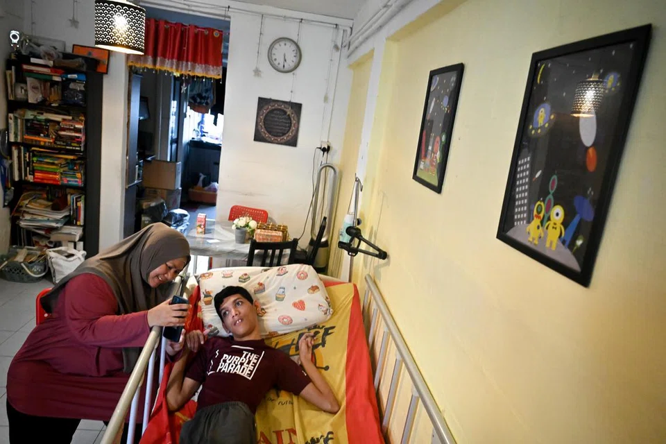 Encik Muhammad Sayfullah Mohamad Sahrin menghidapi palsi serebrum quadriplegic dan isu pertuturan sejak lahir. Beliau kini seorang pereka digital bebas dan bangga dengan hasil karya yang digantung (kanan) di dinding rumahnya. Bersama beliau ialah ibunya, Cik Siti Fadillah Mohamed Noor.