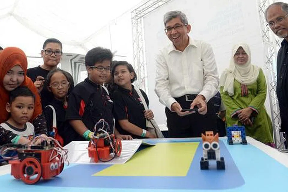 TEKNOLOGI BIJAK: Dr Yaacob menyertai peserta cilik dalam satu kegiatan di Festival Pembelajaran Mendaki. Turut bersamanya ialah Menteri Sekitaran dan Sumber Air, Encik Masagos Zulkifli (kanan), dan CEO Mendaki, Cik Tuminah Sapawi (dua dari kanan). - Foto TAUFIK A. KADER