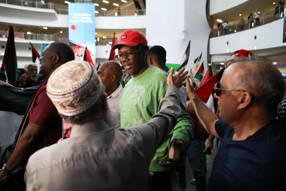 PEGUAM BELA DISAMBUT: Peguam bela, Encik Tembeka Ngcukaitobi (tengah), anggota pasukan undang-undang Afrika Selatan disambut oleh penyokong, selepas mendarat kembali ke negara itu daripada mewakili negara dalam perbicaraan dua hari terhadap Israel di ICJ, pada 14 Januari.