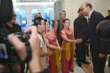 BERAMAH MESRA: Presiden Tharman Shanmugaratnam (kiri) berbual mesra dengan sebilangan para penerima dan hadirin di majlis penyampaian Anugerah Dana Masyarakat di Istana pada Rabu.