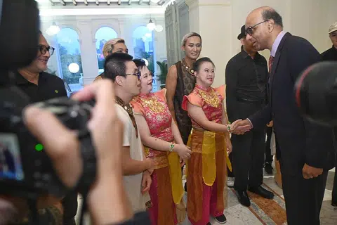 BERAMAH MESRA: Presiden Tharman Shanmugaratnam (kiri) berbual mesra dengan sebilangan para penerima dan hadirin di majlis penyampaian Anugerah Dana Masyarakat di Istana pada Rabu.