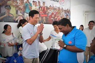 TANDA PENGHARGAAN: Menteri Pendidikan Encik Ong Ye Kung mengagihkan pakej kesihatan kepada pekerja-pekerja sebagai tanda penghargaan.di pusat penjaja Kampung Admiralty. - Foto BM oleh NG SOR LUAN