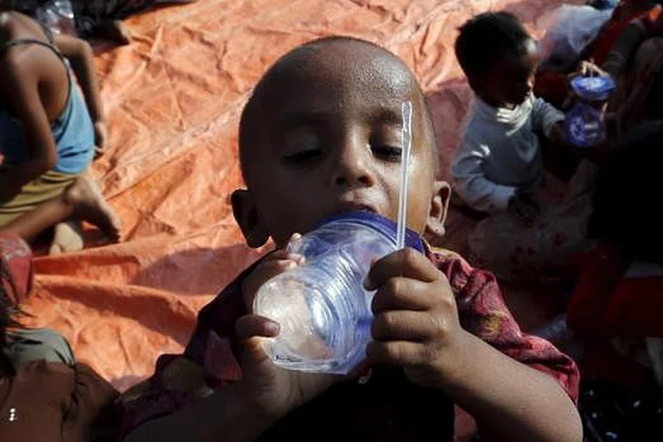 MINUM SETEGUK AIR: Kanak-kanak Rohingya ini meminum air setibanya dia di pelabuhan Julok, perkampungan Kuta Binje, Aceh, semalam. - Foto REUTERS