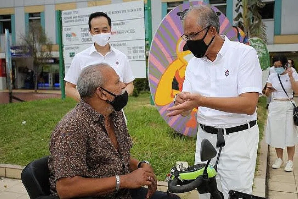 BERIKAN YANG TERBAIK: Encik Masagos sedang berinteraksi dengan seorang penduduk di Tampines, sambil menerangkan antara program dan kemudahan yang terdapat di kawasan undi tersebut. Bersamanya ialah Dr Koh Poh Koon (belakang), muka baru di GRC Tampines menggantikan DPM Heng Swee Keat. - Foto PAP