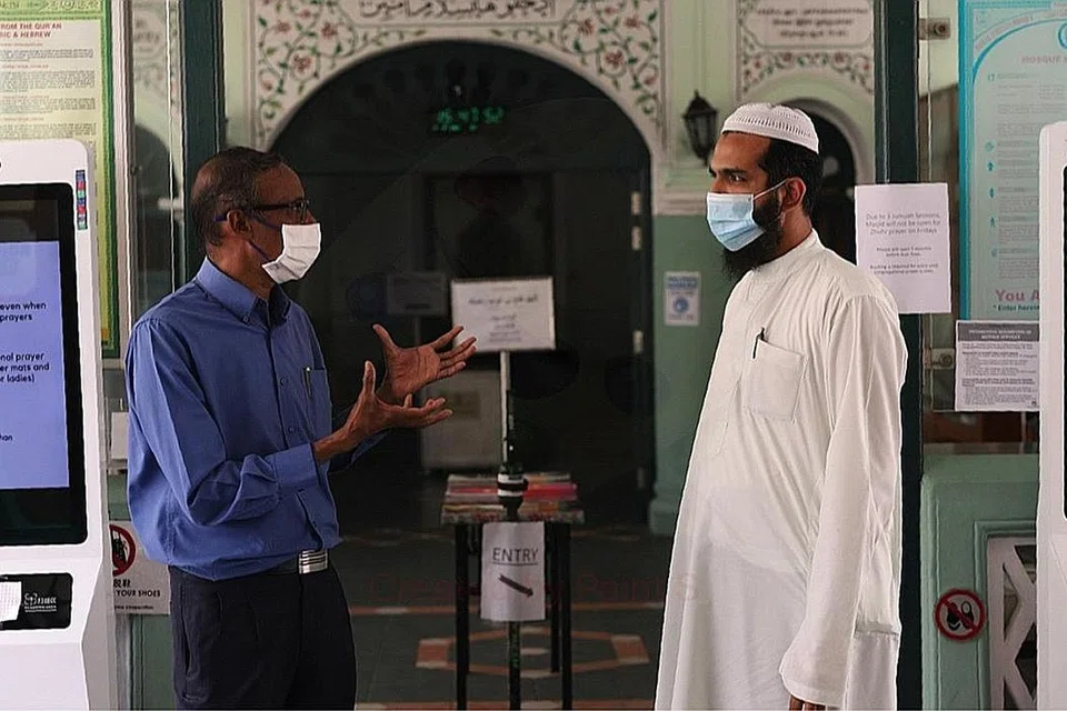 BERBINCANG: Encik Shaick Fakrudeen (kiri) berbual-bual bersama pengurus Masjid Jamae Chulia, Encik Haniff Sultan di hadapan pintu masuk ke dewan solat masjid. - Foto FADLI SAZALI
