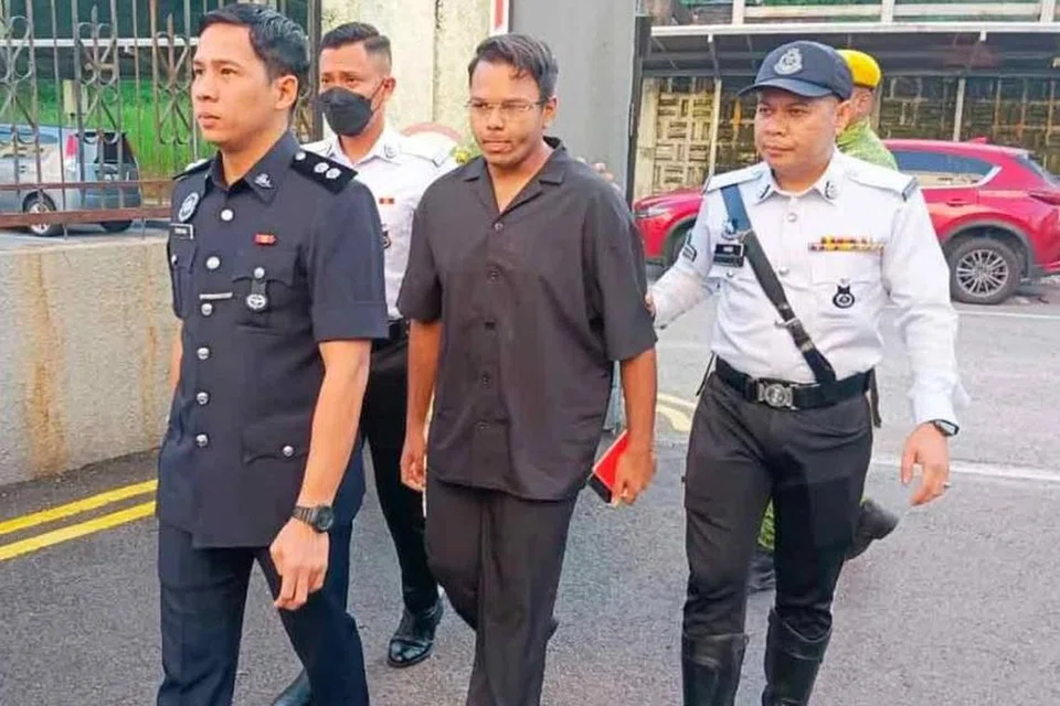 Muhammad Irsyad Abdul Hameed (dua dari kanan) diiringi polis ketika tiba di Mahkamah Majistret Johor Bahru pada 15 Mei.