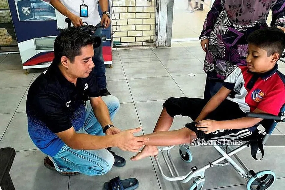 HIDAPI MIOKIMIA; Irfan Wafiy (di kerusi roda) menghidap sejenis penyakit seperti Parkinson yang dinamakan miokimia selepas dia dipercaya terdedah kepada pencemaran di Sungai Kim Kim Mac lalu. - Foto NSTP