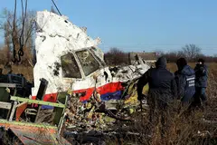PENEMUAN BARU: Pekerja mengangkut serpihan pesawat Malaysia Airlines MH17 di lokasi ia jatuh berhampiran perkampungan Hrabove (Grabovo) di wilayah Donetsk, timur Ukraine, pada 20 November 2014. Penyiasat antarabangsa dijangka membentangkan penemuan baru mereka. - Foto fail