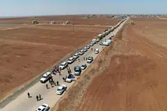 Gambar yang disediakan ini, diterbitkan oleh Agensi Berita Rasmi Arab Syria (SANA) pada 28 Julai 2025, menunjukkan trak Bulan Sabit Merah Syria yang membawa bantuan kemanusiaan tiba di Busra al-Sham di wilayah selatan Daraa, Syria, sebelum melintasi zon penampan menuju ke wilayah Sweida di tengah-tengah gencatan senjata susulan pertempuran sektarian antara pejuang Druze dan puak Badwi Sunni awal bulan Julai.