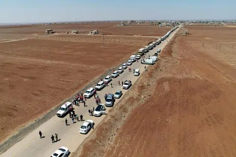 Gambar yang disediakan ini, diterbitkan oleh Agensi Berita Rasmi Arab Syria (SANA) pada 28 Julai 2025, menunjukkan trak Bulan Sabit Merah Syria yang membawa bantuan kemanusiaan tiba di Busra al-Sham di wilayah selatan Daraa, Syria, sebelum melintasi zon penampan menuju ke wilayah Sweida di tengah-tengah gencatan senjata susulan pertempuran sektarian antara pejuang Druze dan puak Badwi Sunni awal bulan Julai.