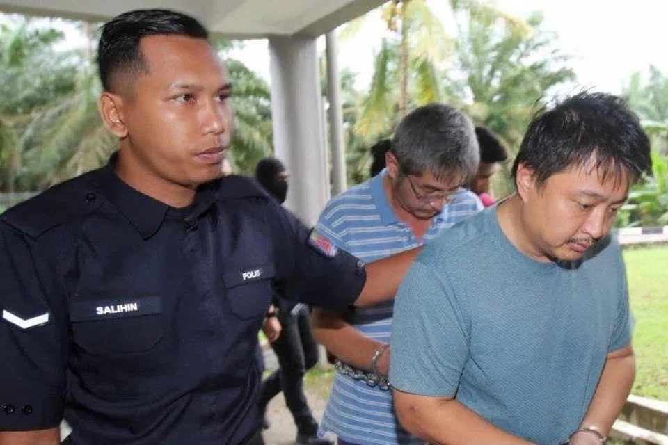 Dua daripada lima tertuduh – warga Singapura Tan Eng Yong (hadapan) dan warga Malaysia Lau Kam Wai – dibawa ke Mahkamah Sesyen Kota Tinggi pada 26 September untuk pendakwaan mencemar sungai di Johor yang menyebabkan kemudaratan terhadap pemeliharaan perkhidmatan air.