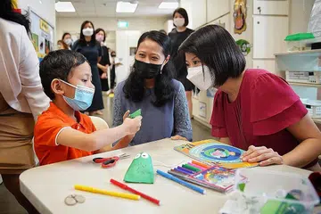 LIHAT PERKEMBANGAN ANAK: Semasa lawatan beliau ke pusat My First Skool di Blok 406 Woodlands semalam, Cik Sun Xueling (kanan) sempat bertemu Cik Sa'adah Mohd Razif dan anaknya, Muhd Fahmi Muhd Faizal untuk melihat perkembangan kanak-kanak itu sejak beliau disertakan dalam Program Sokongan Inklusif atau InSP. - Foto BH oleh JASON QUAH