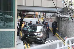 NAHAS BAWA MAUT: Kereta berwarna hitam telah melanggar pagar besi lalu terjatuh ke jalan raya bersebelahan pusat beli-belah Lucky Plaza petang semalam. - Foto ZAOBAO