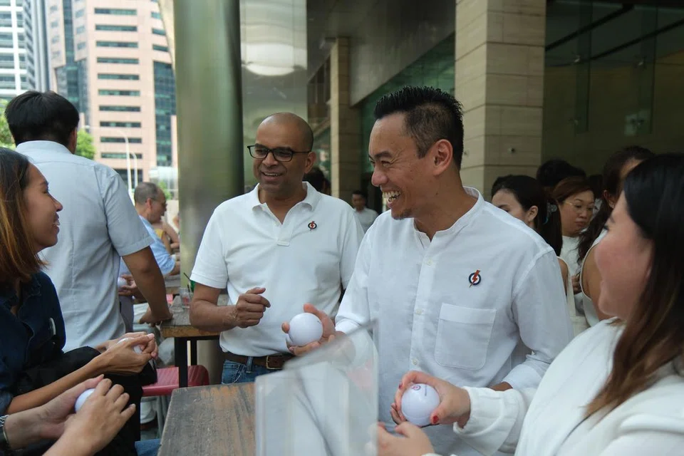 Menteri Negara Kanan (Kesihatan), Dr Janil Puthucheary (tiga dari kanan), yang merupakan Pengerusi Kumpulan Kesihatan Mental Parti Tindakan Rakyat (PAP); dan Naib Pengerusi kumpulan itu, Anggota Parlimen (AP) GRC Jalan Besar, Dr Wan Rizal Wan Zakariah (dua dari kanan) mengedarkan bebola tangani tekanan, ‘stress ball’ kepada orang ramai semasa memperingati Hari Kesihatan Mental Sedunia di NTUC Centre @ One Marina Boulevard pada 10 Oktober. 
