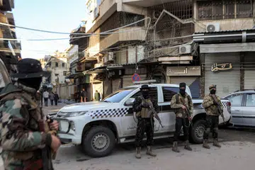 Pasukan keselamatan dikerah di luar Katedral Ortodoks Yunani St George semasa misa pagi Krismas di bandar pesisir Latakia, Syria, pada 25 Disember.