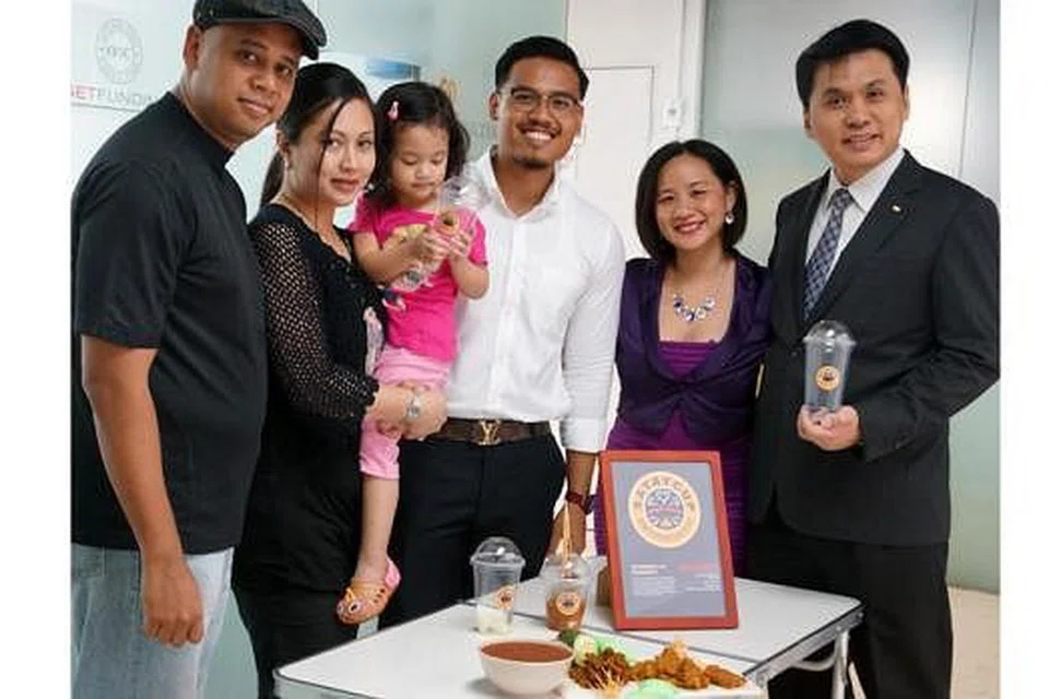 IDEA MENJADI NYATA: Idea menjual sate dalam cawan tercetus dalam diri Encik Shafudin Kassim (kiri) 10 tahun lalu. Bersama isterinya, Cik Sulasteri Samse (mendukung anak mereka), mereka mengasaskan Satay Cup. Kelihatan bersama pasangan ini ialah pengurus cawangan, Encik Rasheed Sazali (berbaju putih), dan dua rakan kongsi mereka, Cik Iris Koh dan Encik Raymond Ng.