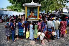 KEHIDUPAN TIDAK BERUBAH: Orang ramai beratur bagi membeli minyak tanah untuk kegunaan rumah di sebuah stesen minyak di Colombo walaupun bilangan mereka melakukan demikian merosot.  