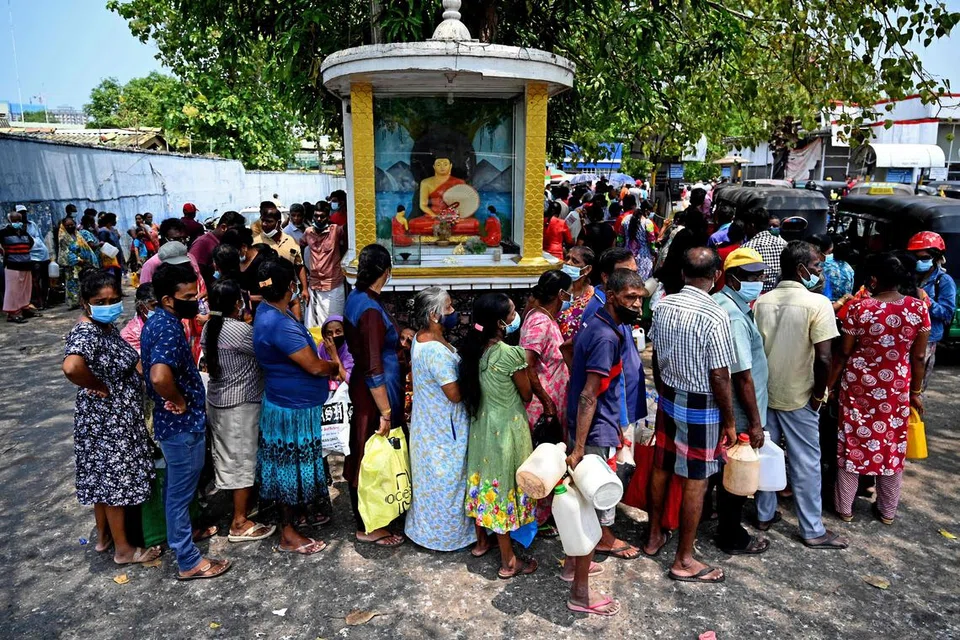 KEHIDUPAN TIDAK BERUBAH: Orang ramai beratur bagi membeli minyak tanah untuk kegunaan rumah di sebuah stesen minyak di Colombo walaupun bilangan mereka melakukan demikian merosot.  