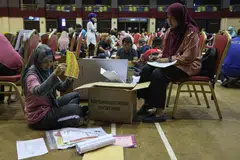 SIBUK BUAT PERSIAPAN: Petugas Suruhanjaya Pilihan Raya (SPR) sibuk melakukan persiapan menjelang Pilihan Raya Negeri (PRN) di Pusat Penjumlahan Rasmi Undi bagi Dewan Undangan Negeri (DUN) N.31 Chukai, Terengganu, di Dewan Datuk Seri Amar Diraja pada 11 Ogos. 