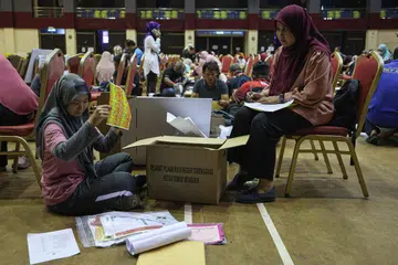 SIBUK BUAT PERSIAPAN: Petugas Suruhanjaya Pilihan Raya (SPR) sibuk melakukan persiapan menjelang Pilihan Raya Negeri (PRN) di Pusat Penjumlahan Rasmi Undi bagi Dewan Undangan Negeri (DUN) N.31 Chukai, Terengganu, di Dewan Datuk Seri Amar Diraja pada 11 Ogos. 
