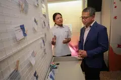 Starlett Seng, pelajar Menengah 2 dari Sekolah Menengah Peicai, memperkenalkan paparan interaktif mengenai cara menangani gangguan dalam talian kepada Menteri Undang-Undang merangkap Menteri Kedua (Ehwal Dalam Negeri), Encik Edwin Tong, di Pusat SHECARES pada 24 Julai.