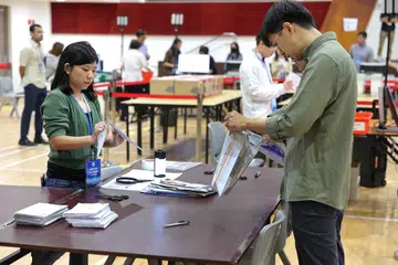 UNDIAN POS: Para pegawai menguruskan undian pos yang diterima daripada warga Singapura di luar negara yang layak mengundi.