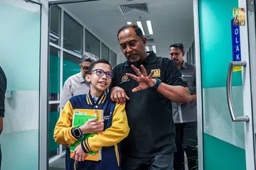 Menteri Pendidikan Tinggi Encik Zambry Abdul Kadir (kanan) berkongsi kata-kata semangat kepada Izz Imil, yang akan memulakan pengajiannya di Universiti Malaya.