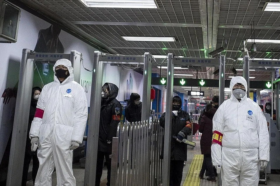 PEMERIKSAAN KETAT: Kakitangan keselamatan mengenakan pakaian perlindungan untuk membantu mencegah penularan virus Wuhan berjaga di stesen rel di Beijing. - Foto AFP