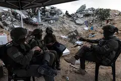 Tentera Israel duduk bersama di tengah runtuhan bangunan di Rafah, selatan Jaluran Gaza, 8 Disember 2025.