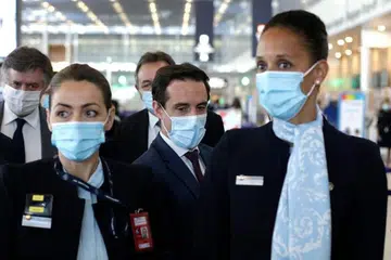 ORAK LANGKAH SEGERA: Menteri Pengangkutan Perancis, Encik Jean-Baptiste Djebbari (tengah) mengunjungi Lapangan Terbang Orly di selatan Paris dalam usaha menyegerakan ujian penerbangan dalaman yang menggunakan pasport vaksin sebagai langkah mengembalikan pengembaraan udara. - Foto AFP 