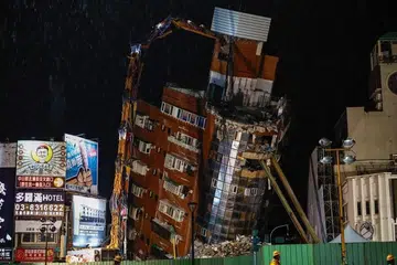 Para pekerja dilihat berhampiran bangunan kediaman Uranus yang sebahagiannya runtuh berikutan gempa bumi magnitud 7.4 di Taiwan.