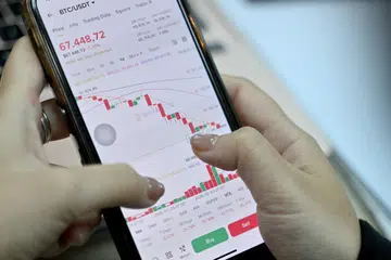 Foto yang diambil pada 12 Februari 2026 menunjukkan seorang pelabur mata wang kripto Vietnam melihat nilai terkini Bitcoin melalui telefon pintarnya di Hanoi. Sebagai pelajar tahun pertama sains komputer di Hanoi, Hoang Le mula berdagang kripto dari bilik asrama universitinya, didorong rakan-rakan yang meraih keuntungan besar, sehingga pegangan digitalnya pernah mencecah AS$200,000 ( S$272,000)  kira-kira 50 kali ganda purata pendapatan tahunan di Vietnam. Namun, nilainya menjunam ke sifar apabila harga Bitcoin dan mata wang kripto lain merudum dalam beberapa bulan kebelakangan ini.